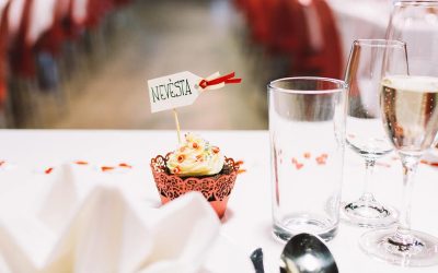 A table setting with a cupcake and a glass of wine.