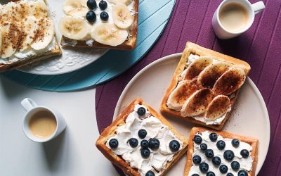 Waffles with blueberries and bananas on a plate.